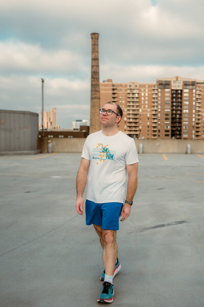 Ryan standing on a rooftop in Minneapolis during his dating profile photography session, arms open and confident.