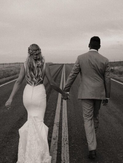 just-married-bride-and-groom-walking-on-road