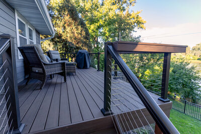 Composite deck with cable railing and a custom wide drink rail. 
