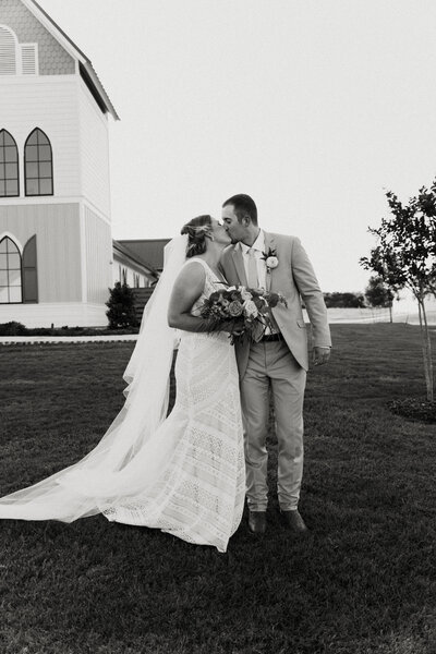 black and white image bride and groom kissing