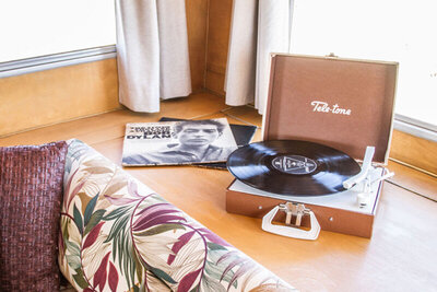 Place branding image portable record player next to bed interior mini airstream Gatos Trail Ranch
