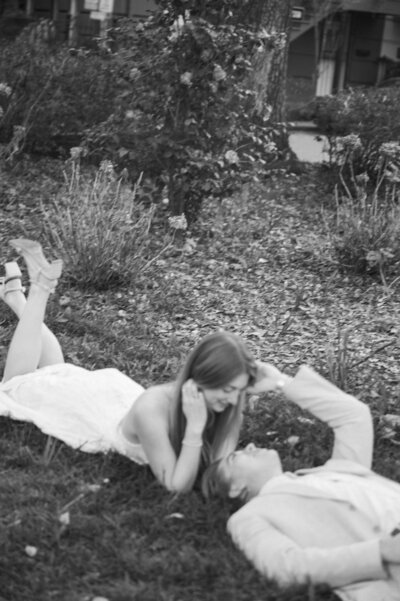 bride and groom laying down in park
