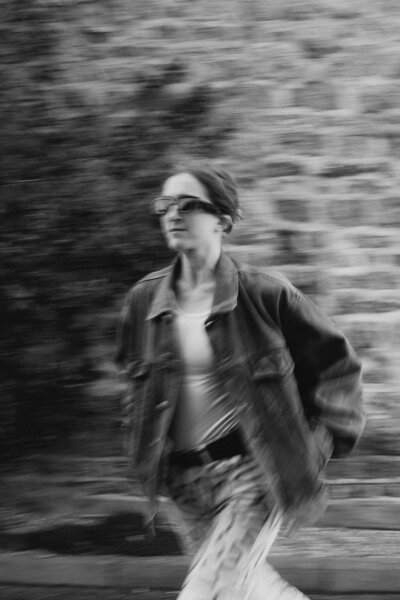 Busy working mum and coach walks across the road in Oxfordshire against Cotswold stone
