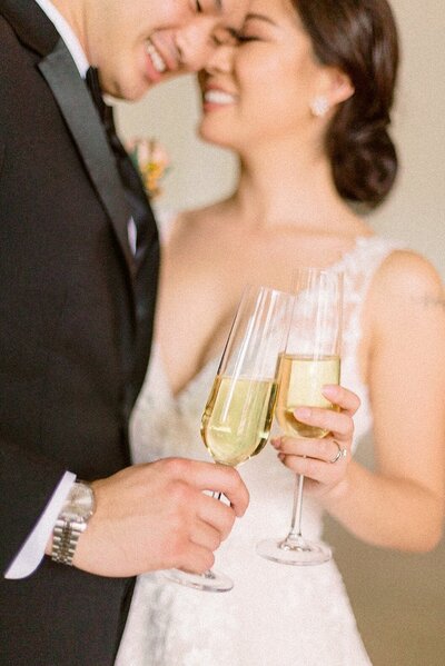 Couple cheers champagne glasses at wedding