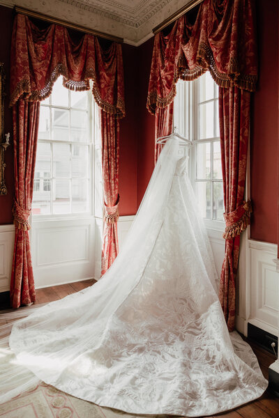 Wedding dress hanging at golden mirror