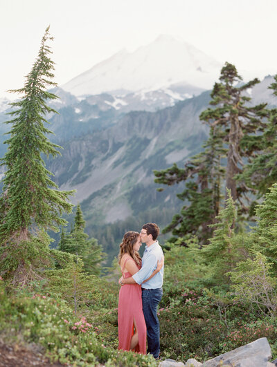 a man and woman nicely dressed kissing over a table at a corner cafe in Paris
