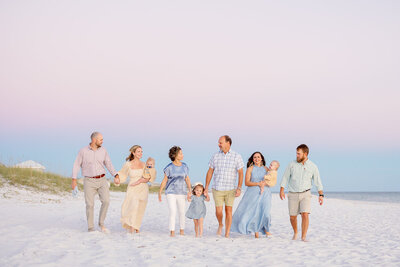 walking family photo on 30a sunset at dusk with pink sky