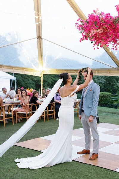 A newlywed playing a lei over their partner's head 