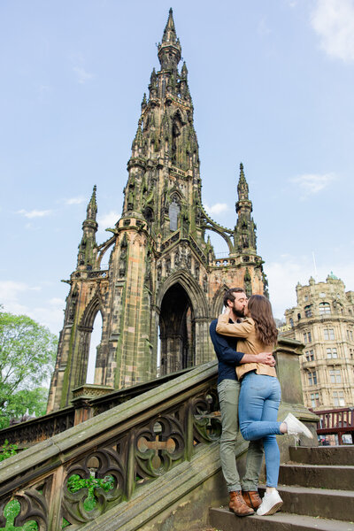 Edinburgh engaged couple kisses in front of spire