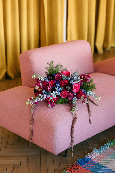 Vibrant bouquet laying on pink chair at Nashville wedding