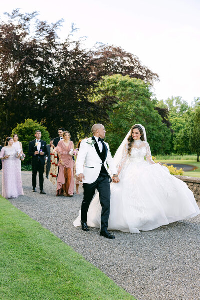 candid image of the new husband & wife walking to cocktail hour together after their wedding ceremony