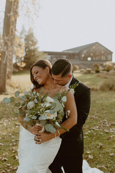 groom kissing bride on neck