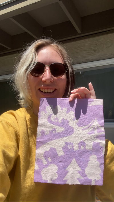 Jules holding a purple print artwork