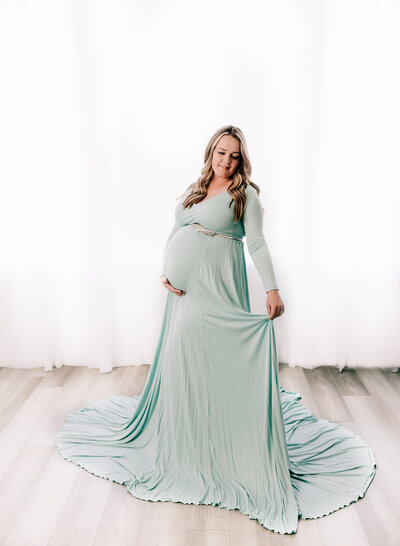 Pregnant mom in a beautiful mint maternity gown.