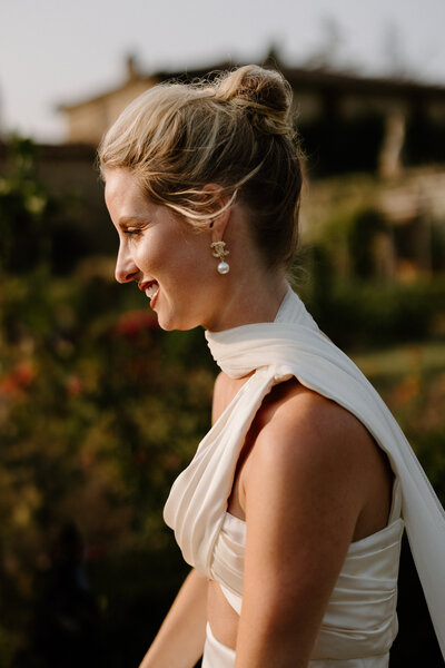 A person in a wedding dress looking down and smiling 