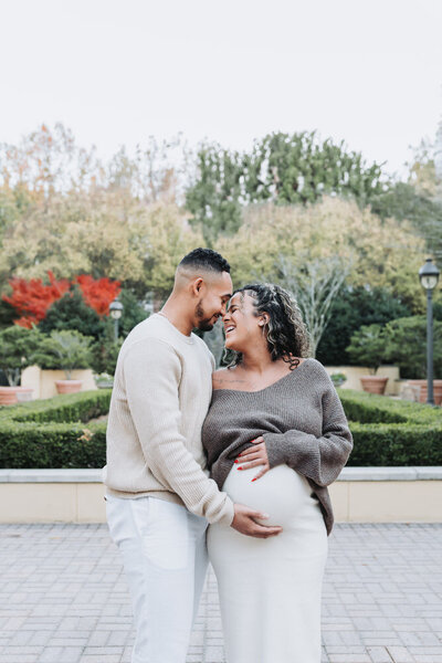 man holds woman's pregnant belly