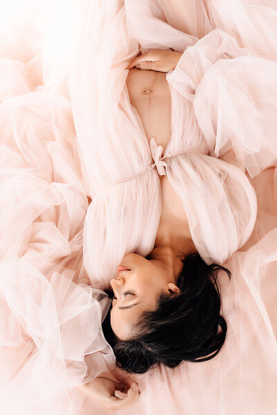 Pregnant mom in pink tulle gown for maternity session
