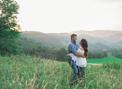 young couple hugging and looking at each other in a field