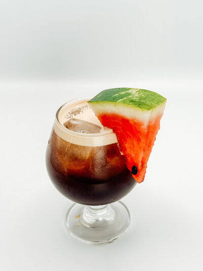 Watermelemonade from Quigley Coffee Co, a refreshing iced coffee and lemonade fusion topped with a fresh watermelon slice.