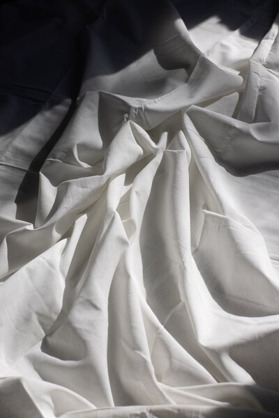 Messy white sheets in light