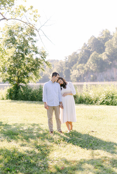 knoxville maternity photographer man and women walking through a field leaning into one another