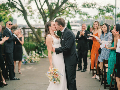 a bride and groom kissing in the aisle after their wedding ceremony  in seattle washington