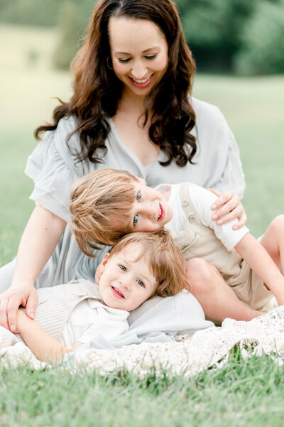 A family of 4 play in a field at sunset by Nashville Newborn Photographer Kristie Lloyd