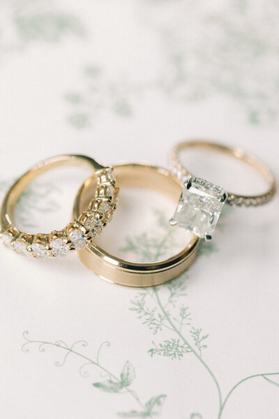 wedding bands that are gold on top of floral paper