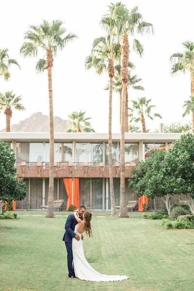 bride and groom kissing at Hotel Valley Ho in Scottsdale Arizona with palm trees and mountain views