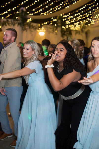 woman singing with bridesmaids at a wedding