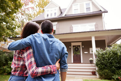 Couple holding each other outside a home in Utah