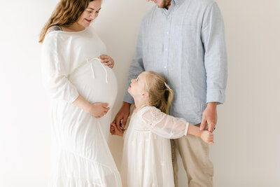 sweet family of three shares a moment together during their maternity session expecting twin babies in Omaha