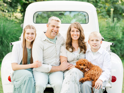 Family of JHP team members sitting in a white truck outside.