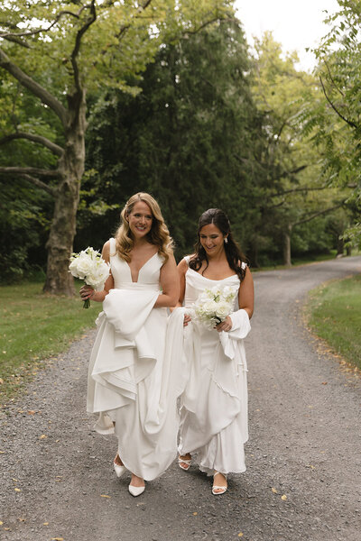 Black and white image of bride hugging groom while holding up a peace sign