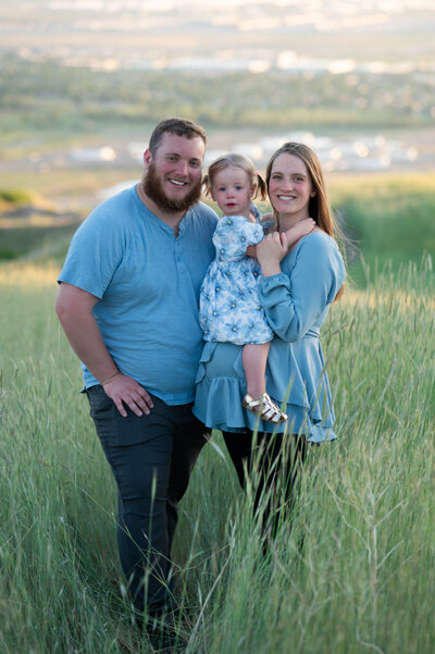 Family of three posing on the mountainside in Utah for a Utah County Family Photographer.