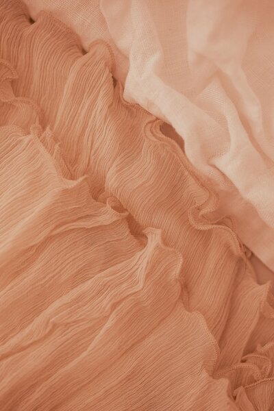 Close-up of a piece of fabric in Pantone Peach Fuzz 2024 color of the year