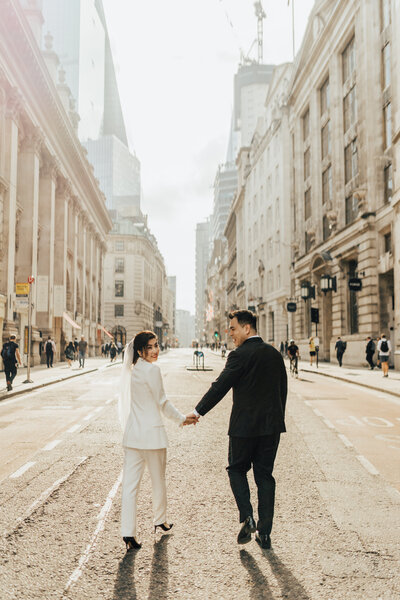 bride and groom holding hands in confetti line