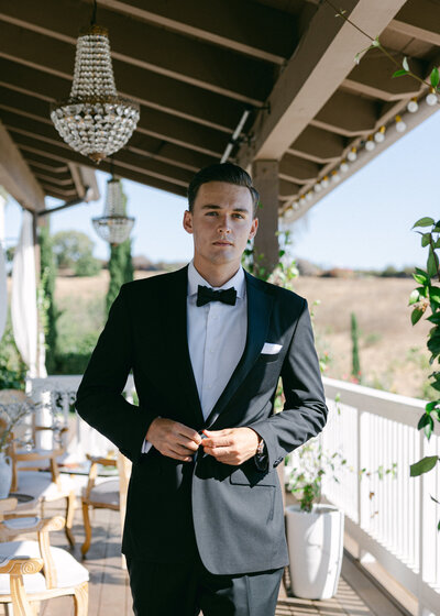 Groom poses for photo as he walks on the balcony of this Southern California Wedding Venue at Jeune Perche. 