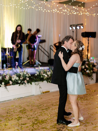 November wedding at Graylyn Estate, designed and planned by Charming Carolina — bride and groom sharing a private last dance surrounded by gold confetti in the Atlantis Room while the band plays.