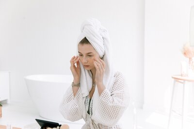 women rubbing a cream on her face