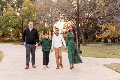 Family walking hand in hand at sunset at Columbia SC State House during fall family photo session by Emily Ann Photography