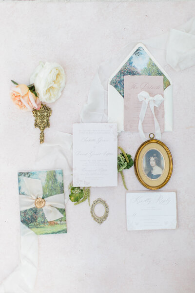 Flat lay of luxury wedding stationery suite with florals and ribbons