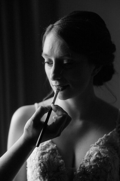 A bride getting her makeup touched up on her elopement day in Glen Etive, Scotland