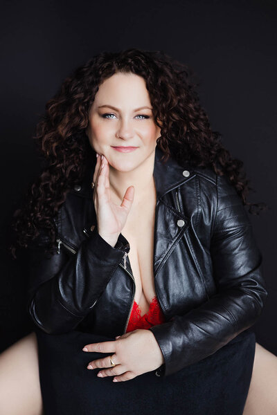 During a Vancouver Boudoir Photoshoot a woman looks out a window while wearing angel wings
