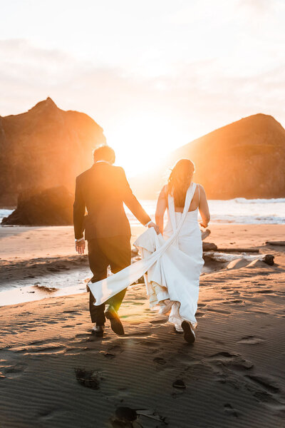 Couple walking along the ocean after their Oregon Coast elopement