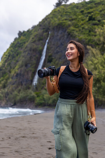 Big Island photographer holding camera in front of the ocean