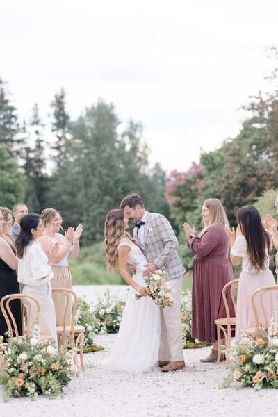 Bride and groom first kiss at their wedding ceremony outdoors at Le Peaches and Cream in Justin, Low, Quebec