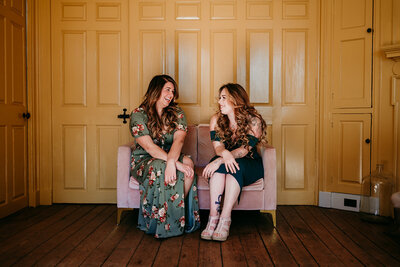 New Jersey wedding photographers Sam and Lisa sitting on a velvet pink couch smiling at each other