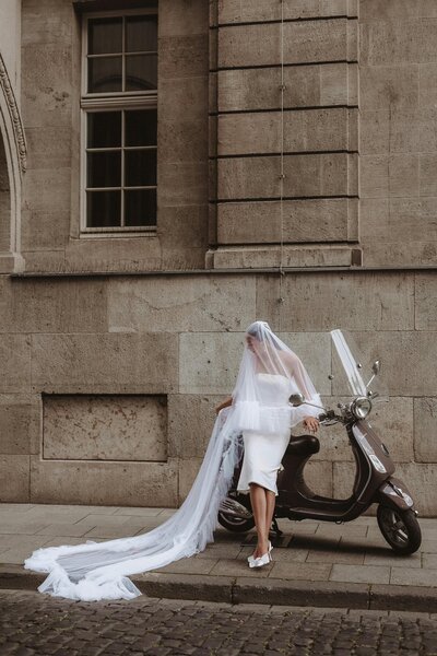 Modern bride siting on a vespa in italy