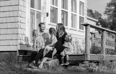 Family sitting on porch, parents looking at each other | Family Photography